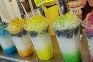 A glass of alouda with basil seeds and ice cream on top.