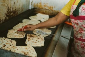 A plate of dholl puri filled with curry and pickles.