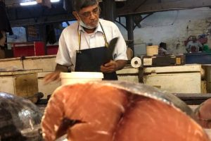 Fishmonger selling fresh seafood at Port Louis Central Market, Mauritius