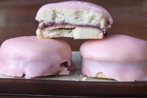 A plate of vibrant pink gâteau napolitaine on a rustic table.