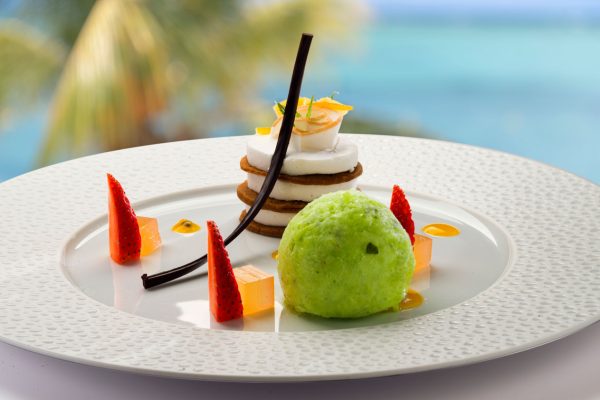 Beachfront dining setup at sunset at LUX Le Morne Resort