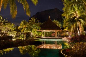 Aerial view of LUX Le Morne Resort with lush gardens, turquoise waters, and Le Morne Brabant Mountain in the background.