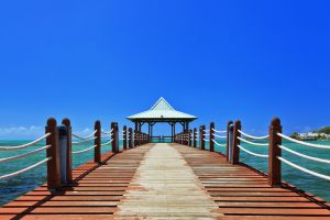 Scenic view of Mahébourg waterfront with boats and mountains in the background