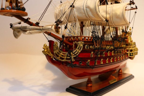 A selection of traditional Mauritian ship models displayed on a wooden shelf.