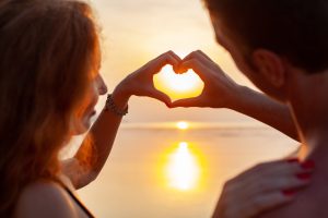 A couple enjoying a romantic sunset on a pristine beach in Mauritius during their honeymoon.