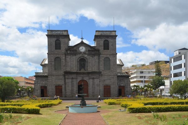 The façade of St. Louis Cathedral, framed by lush greenery.